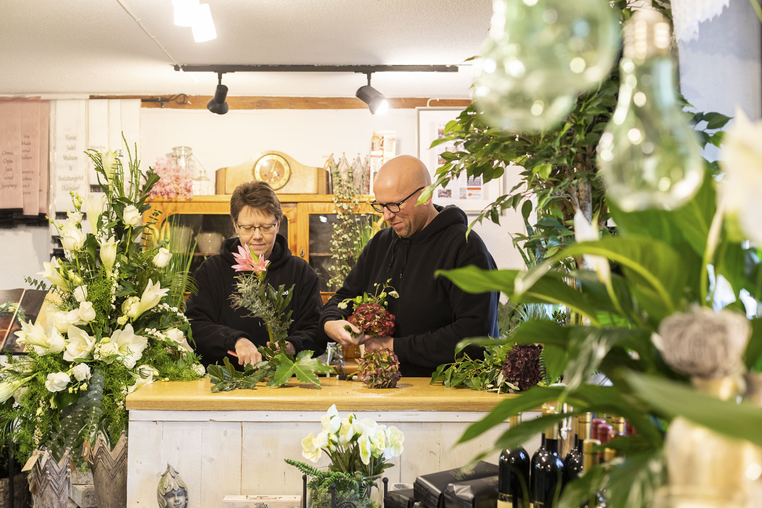Florist Nicky Judel bindet mit einer Mitarbeiterin einen Blumenstrauß